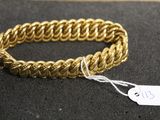 a close up of a gold bracelet with a tag on it