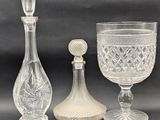 three glass vases and a decanter on a table
