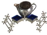 a silver tea pot and four blue glass cups on a stand
