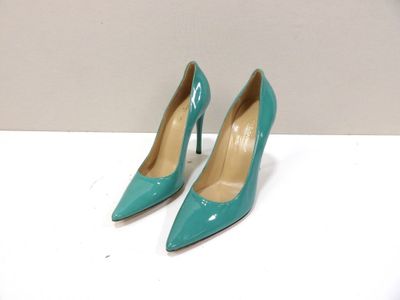 une paire de chaussures à talons hauts bleues posée sur une table blanche