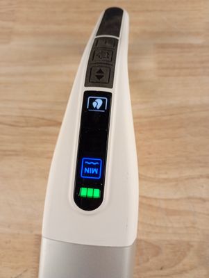 a close up of an electronic device on a wooden table