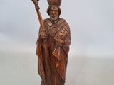 wooden figurine of a priest holding a staff and a cross