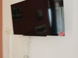 une télévision à écran plat fixée au mur au-dessus d'un radiateur