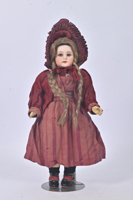 une poupée qui porte une robe rouge et un chapeau