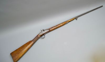 a rifle with a wooden handle on a white surface