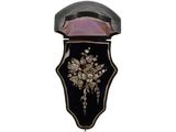 a black and gold brooch with flowers on it
