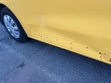 a yellow car that has holes in the side of it
