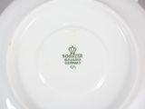 a close up of a white plate with a crown on it