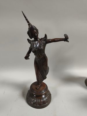 three bronze figurines of a woman holding a sword and a vase