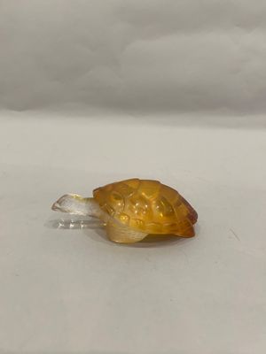 a small glass snail that is sitting on a table