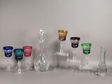 plusieurs vases en verre de différentes couleurs sont alignés sur une surface blanche