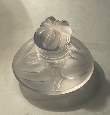 a glass bowl with a flower on it on a table