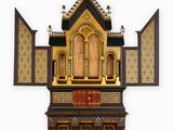 a small wooden shrine with a cross on top of it
