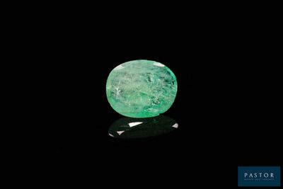 un gros plan d'une émeraude verte sur une surface noire
