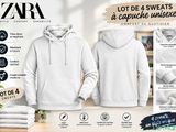 un sweat-shirt blanc à capuche et une serviette posés sur une table