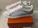 Quelqu'un porte une paire de baskets bleues avec des lacets blancs.