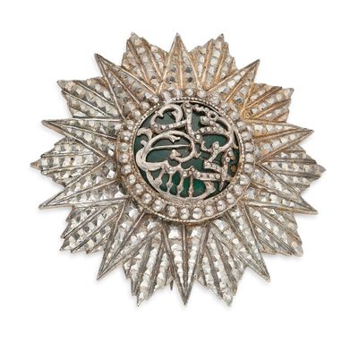 un gros plan d'une broche en argent avec un cœur vert