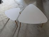 deux tables blanches posées à même le sol dans une pièce
