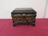 a black and gold chest sitting on top of a red carpet