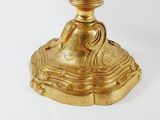 a gold candle that is sitting on a white table