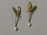 une paire de boucles d'oreilles ornées de feuilles et de perles