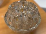 a clear glass bowl on a table with a spoon in it
