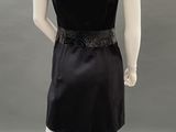 an image of a mannequin wearing a black dress with sequins on the shoulders
