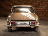 a car that is parked in a garage with a brick wall in the background