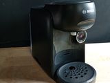 a black coffee maker sitting on a wooden table