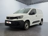 La camionnette blanche est garée dans une grande pièce.