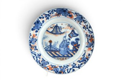 une assiette bleue et blanche ornée d'un motif bleu et orange