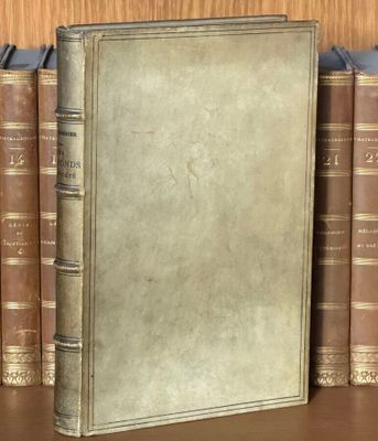 un livre posé sur une étagère, devant une pile de livres