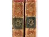 two old books sitting on top of each other on a white surface