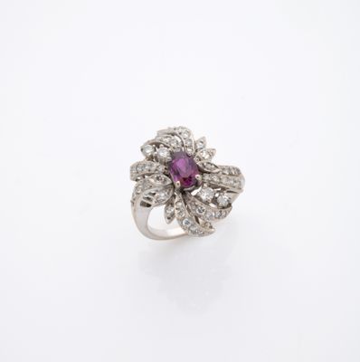 gros plan d'une bague en diamant et rubis sur une surface blanche