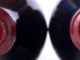 two bottles of red wine sitting next to each other