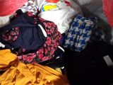 a pile of clothes that is sitting on a bed