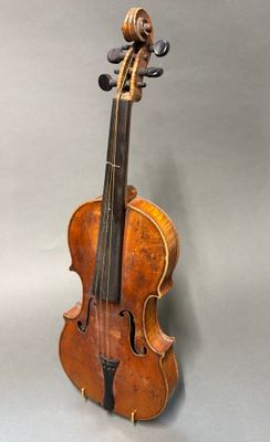 un vieux violon posé sur une table près d'un mur