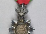 silver medal with a red ribbon and a star on it