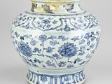 a blue and white vase with a lid on a table