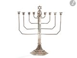 a silver metal menorat with five candles and a star of david on top