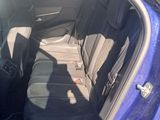 the back seat of a blue car with the door open