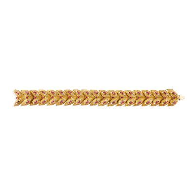 un gros plan d'un bracelet en galon doré sur fond blanc