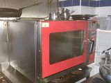 un micro-ondes rouge posé sur une cuisinière dans une cuisine