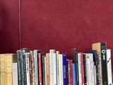 de nombreux livres posés sur une table devant un tableau