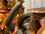 a statue of a boy holding a candle in his hand