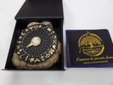 clock in a box on a table with a card in the background
