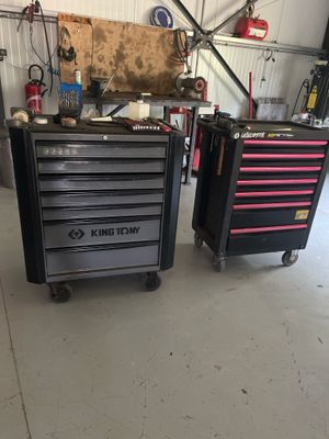 deux coffres à outils noirs et roses posés sur un sol blanc