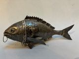 a metal fish that is sitting on a table