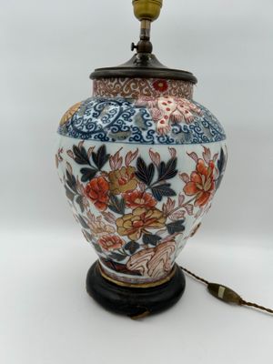 une lampe posée sur une table où se trouvent des fleurs