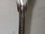 a silver spoon with a spoon handle on a table